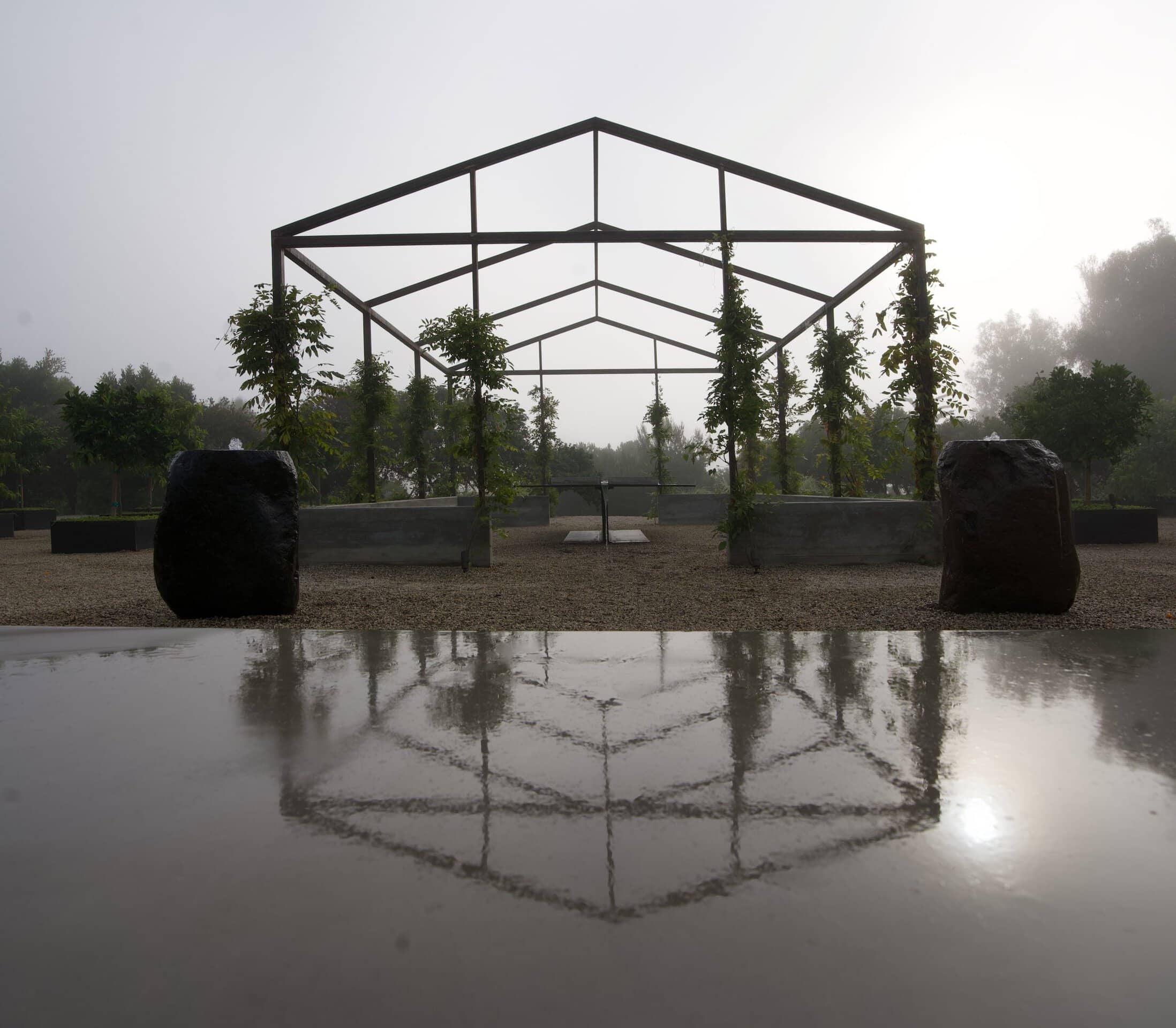 Dots art installation by Brigitte D'Annibale. Items in gray and white clustered on a sandy field